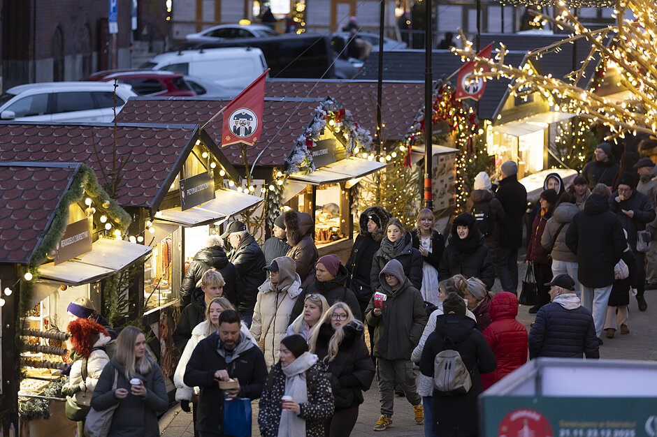 plac z iluminacją świąteczną na środku, wokół zabytkowe budynki i ludzie