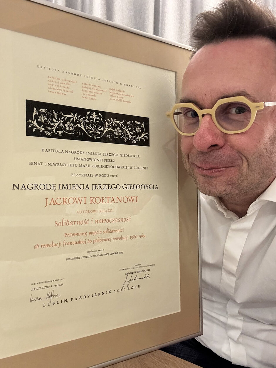 Twarz laureata po prawej, dyplom nagrody po prawej