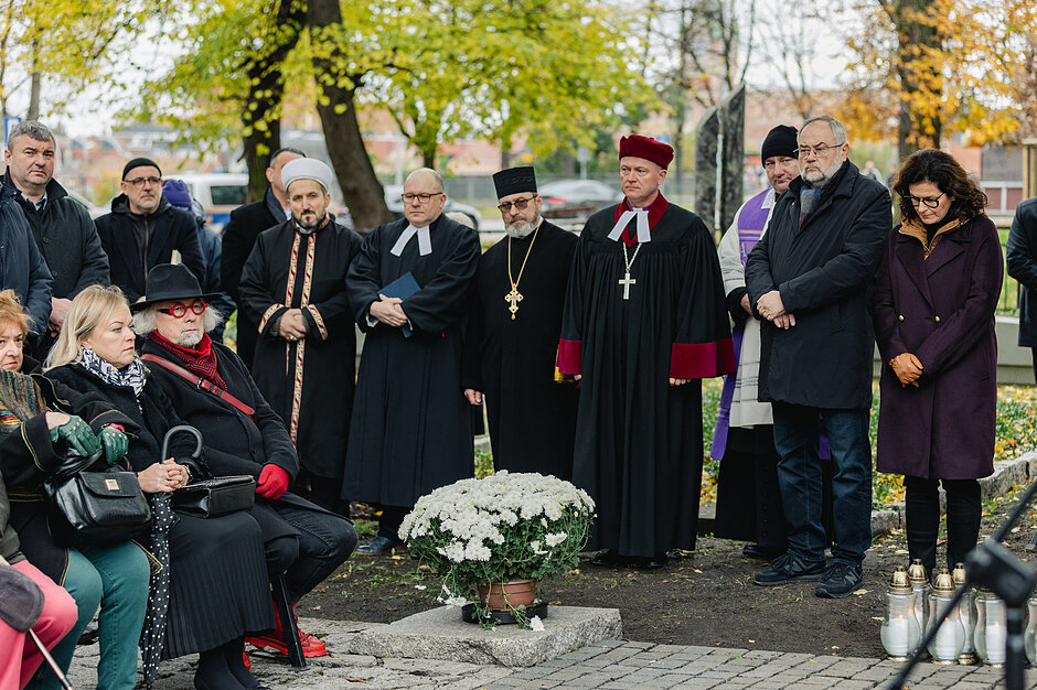 Rząd kapłanów w szatach religijnych - uczestnicy modlitwy na cmentarzu nieistniejących cmentarzy