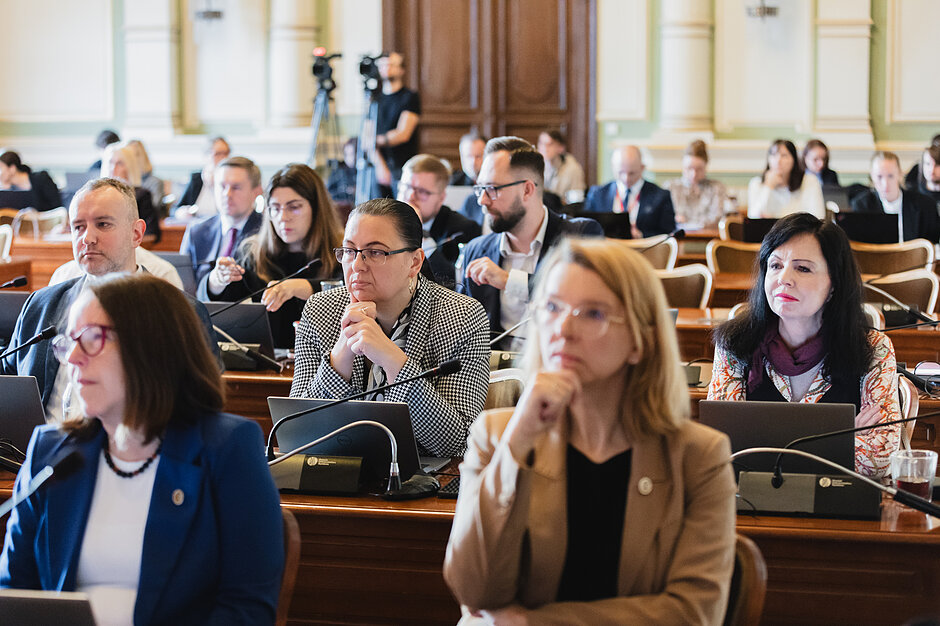 Mężczyźni i kobiety siedzący w ławach