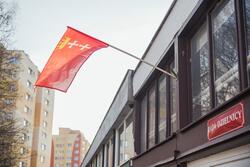 flaga Gdańska zatknięta w elewacji budynku na którym jest tablica Rada Dzielnicy Stogi