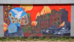 Mural: postać strażaka, który w obecnej sytuacji na Ukrainie, musi mierzyć się nie tylko z żywiołem ognia, wywołanym przez bomby zrzucone przez najeźdźców, ale również z napastnikami pod postacią czołgów, które utrudniają mu ratowanie ludzkiego życia