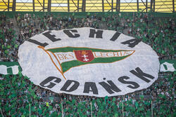 Trybuny zakrywa ogromny okrągły biały baner: U góry napis LECHIA, w środku flaga klubu, na dole napis: GDAŃSK