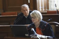 Prokurator i adwokat ubrani w togach na sali sądowej 