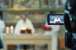 kamera w zabytkowym kościele, w jej wizjerze widać kapłana za ołtarzem