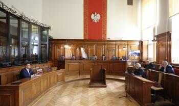 sala rozpraw - w ławach siedzą adwokaci, przed nimi sędziowie, nad sędziami jest symbol orła białego w koronie