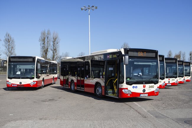 Kilka czerwonych autobusów stoi na placu 