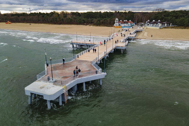 zdjęcie z drona, widać molo drewniane wchodzące jakby w głąb morza