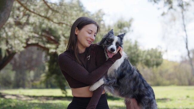 Dziewczyna z psem na tle zieleni