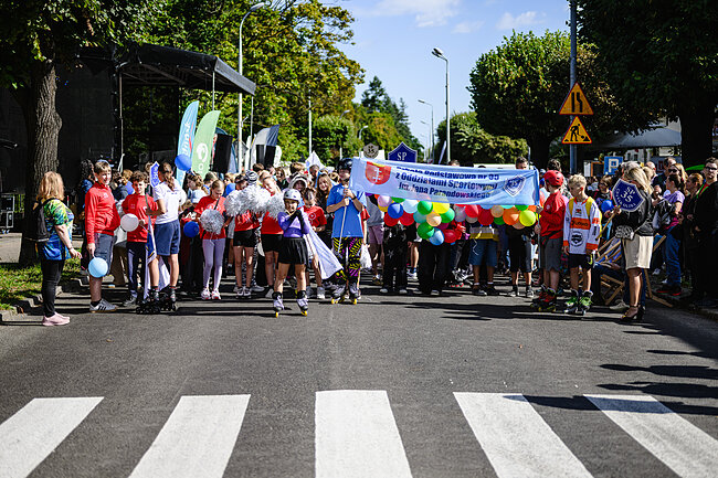 VIVA OLIVIA - święto dzielnicy 2026. Zdjęcie korowodu. Ludzie trzymają banery.