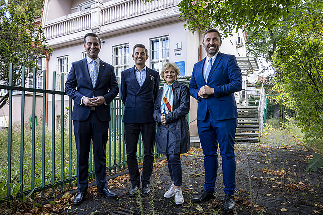 wymienione osoby pozują przed starą willą