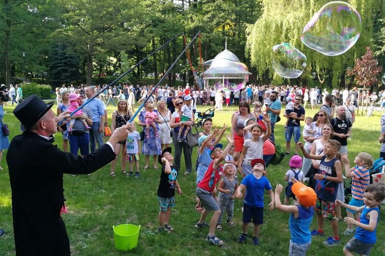 Czarodziej w stroju sprzed epoki wyczarowuje bańki mydlane w Parku Oruńskim