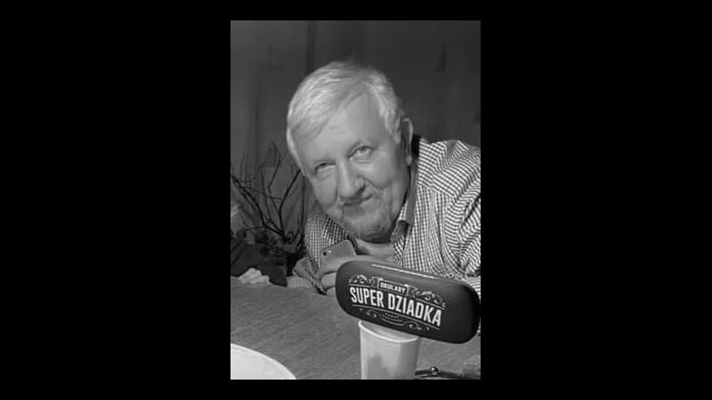 Czarno-białe zdjęcie: twarz starszego mężczyzny przy stole, przed nim kubek z nadstawką z napisem SUPER DZIADEK