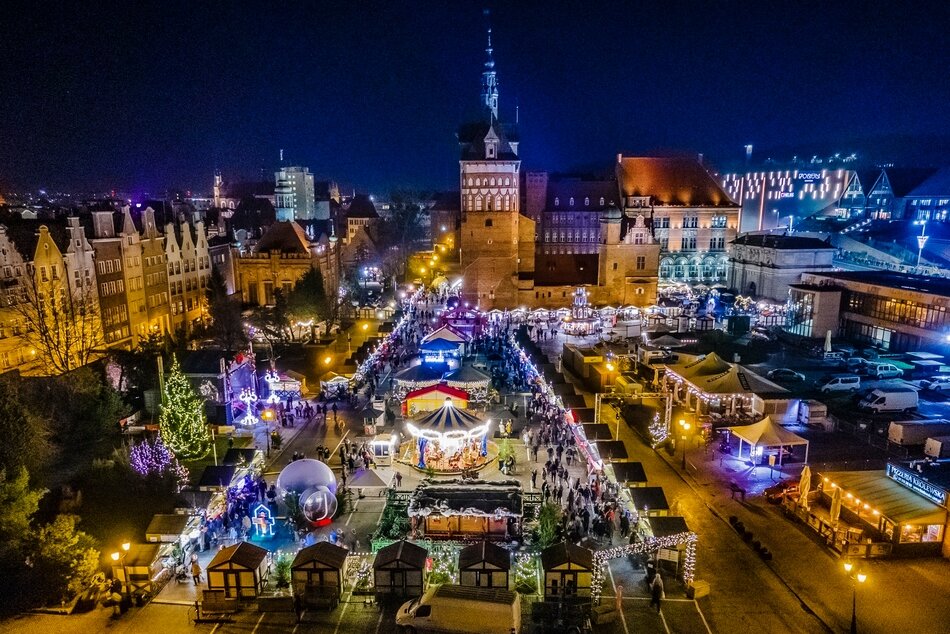 Widok z góry: rozświetlony fragment miasta, budynki, uliczki, straganiki