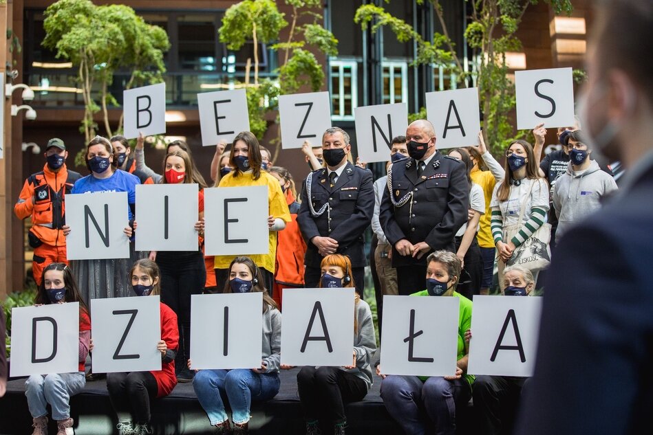 grupa młodych ludzi trzyma kartki z literami układającymi się w napis Bez nas nie działa