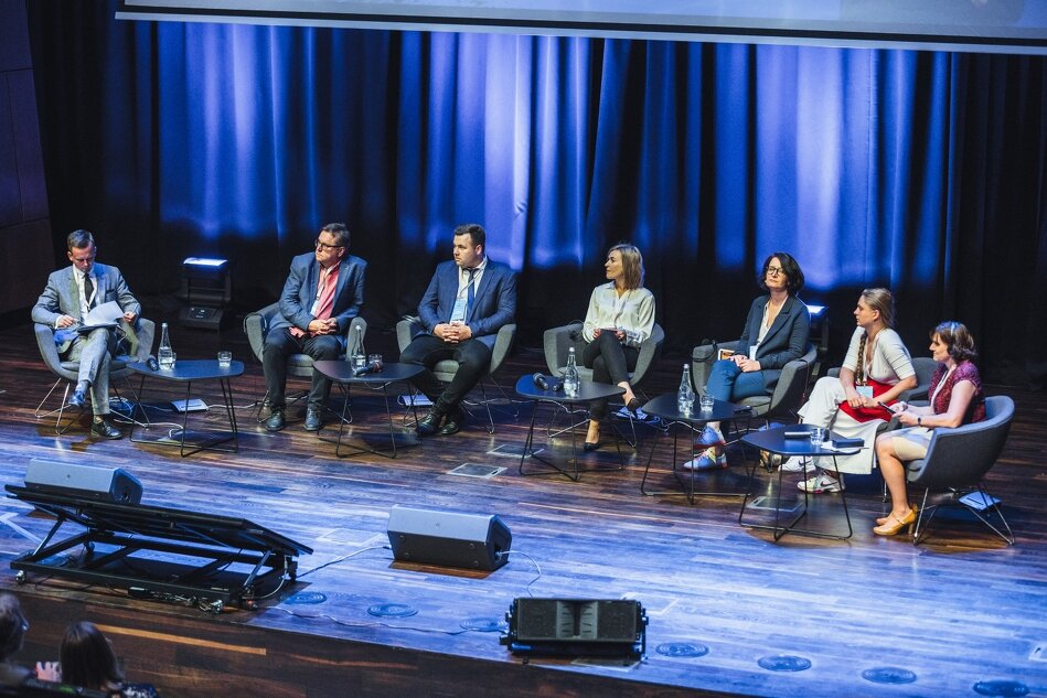 z dalekiej perspektywy, grupa 7 osób siedzących na podium