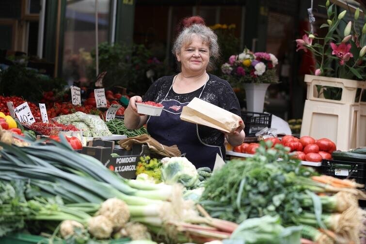 Kobieta (ekspedientka) na stoisku warzywnym na targu