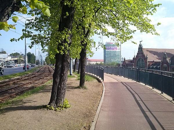 Droga rowerowa wzdłuż ul. 3-go Maja na wysokości Sądu Rejonowego Gdańsk-Południe w Gdańsku. W perspektywie widoczny budynek Dworca Głównego i Zieleniak.