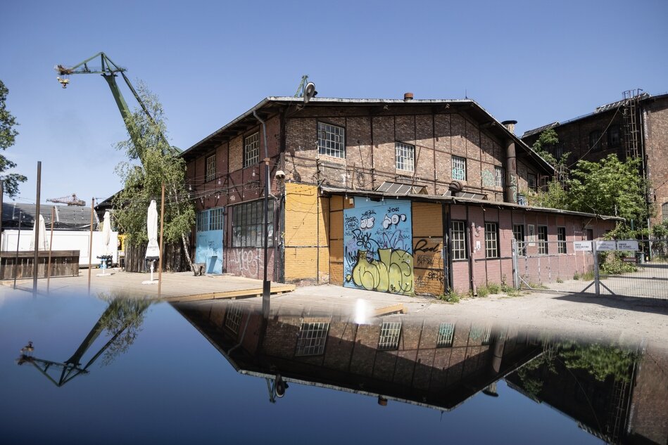 budynek przemysłowy z czerwonej cegły, zniszczony i pomalowany graffitti