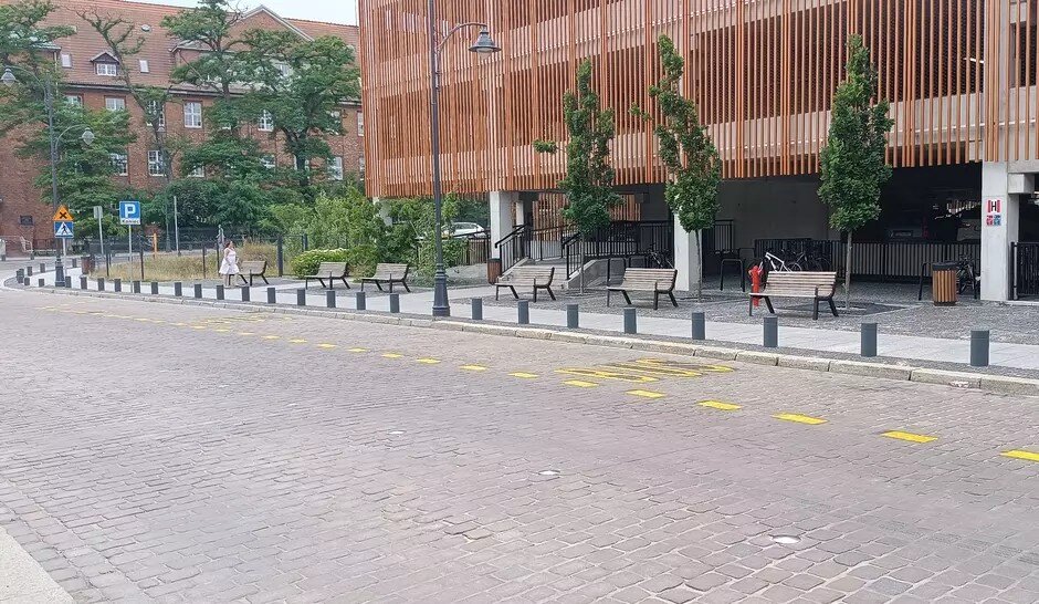 Ulica, po prawej przy krawężniku pas jezdni odznaczony żółtą linią, w środku napis: BUS