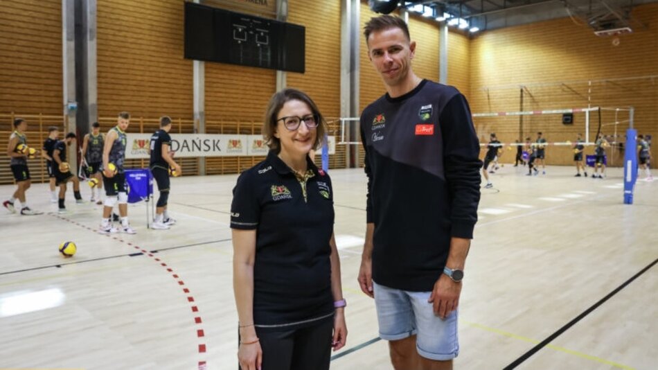 Kobieta w okularach i wysoki mężczyzna stoją obok siebie na sali sportowej