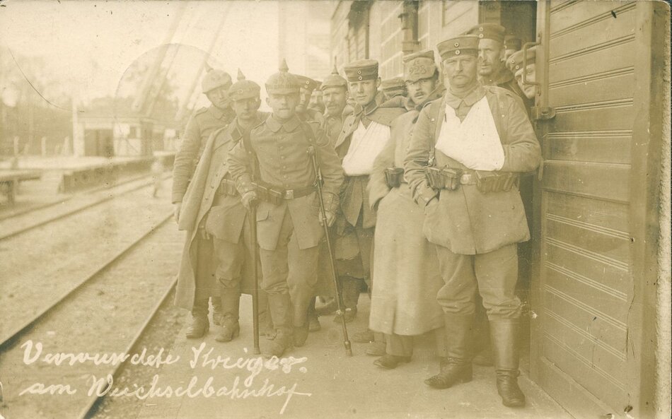 Sepia: kilku mężczyzn stoi przy ścianie, jeden za drugim