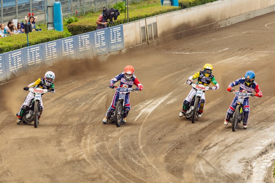 Czterech żużlowców jedzie obok siebie