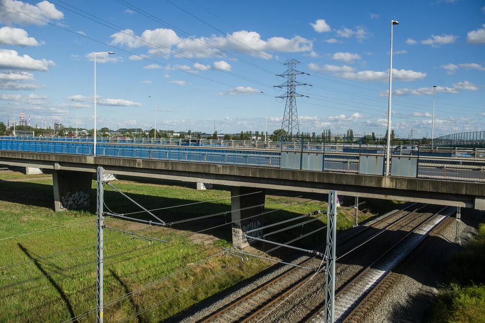 Wiadukt, pod nim trawnik i tory kolejowe