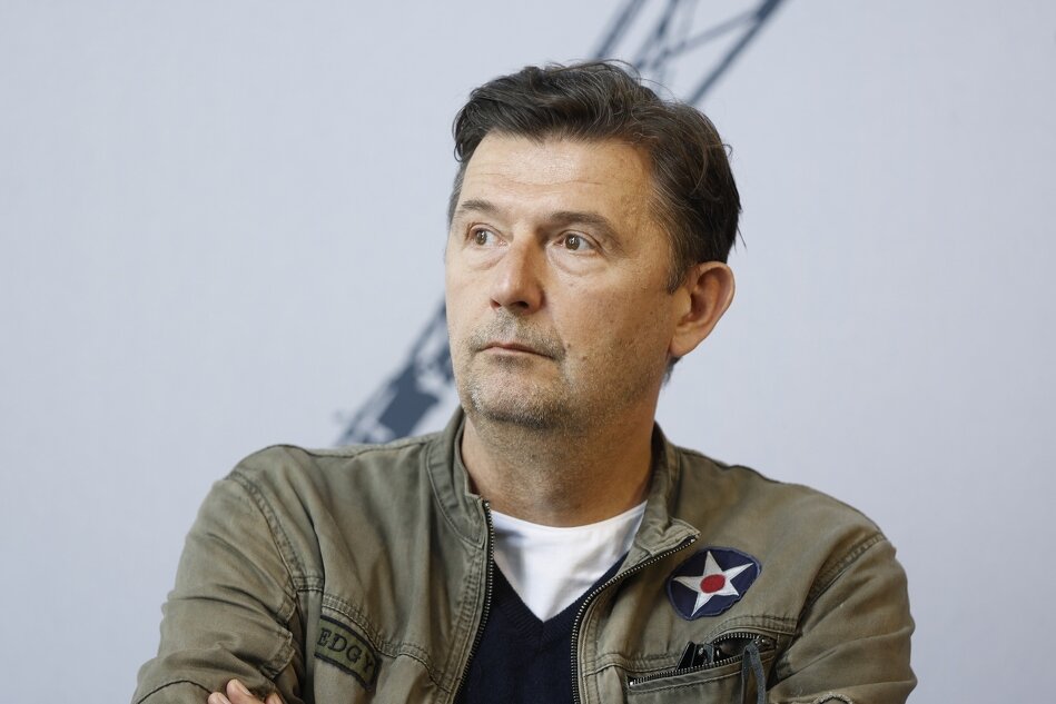 mężczyzna w średnim wieku patrzy zamyślony w bok