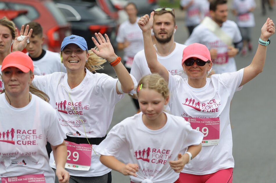 kobiety w różnym wieku w koszulkach sportowych z napisem Race for the cure i numerami startowymi