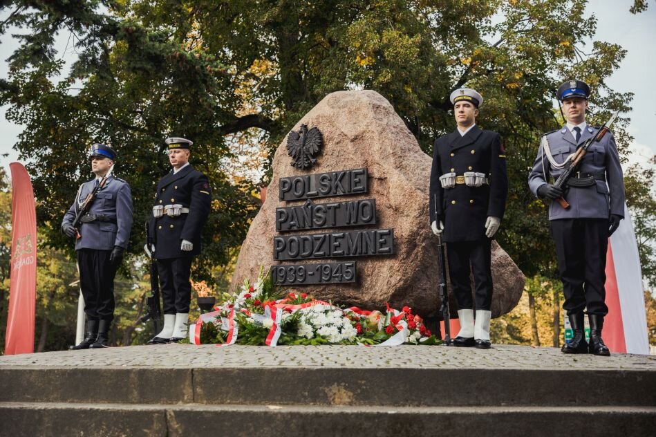 warta żołnierska przy kamiennym pomniku z symbolem Polski Walczącej
