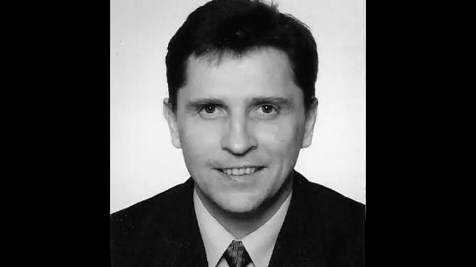 Czarno-białe zdjęcie: twarz uśmiechniętego mężczyzny w średnim wieku