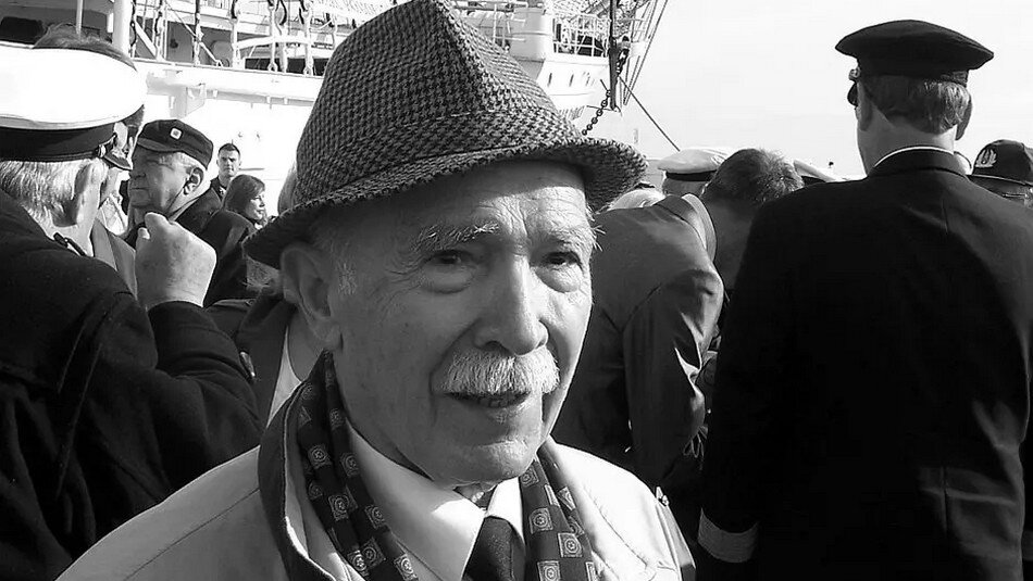 Czarno-białe zdjęcie: twarz starszego mężczyzna w kapelusiku i płaszczu