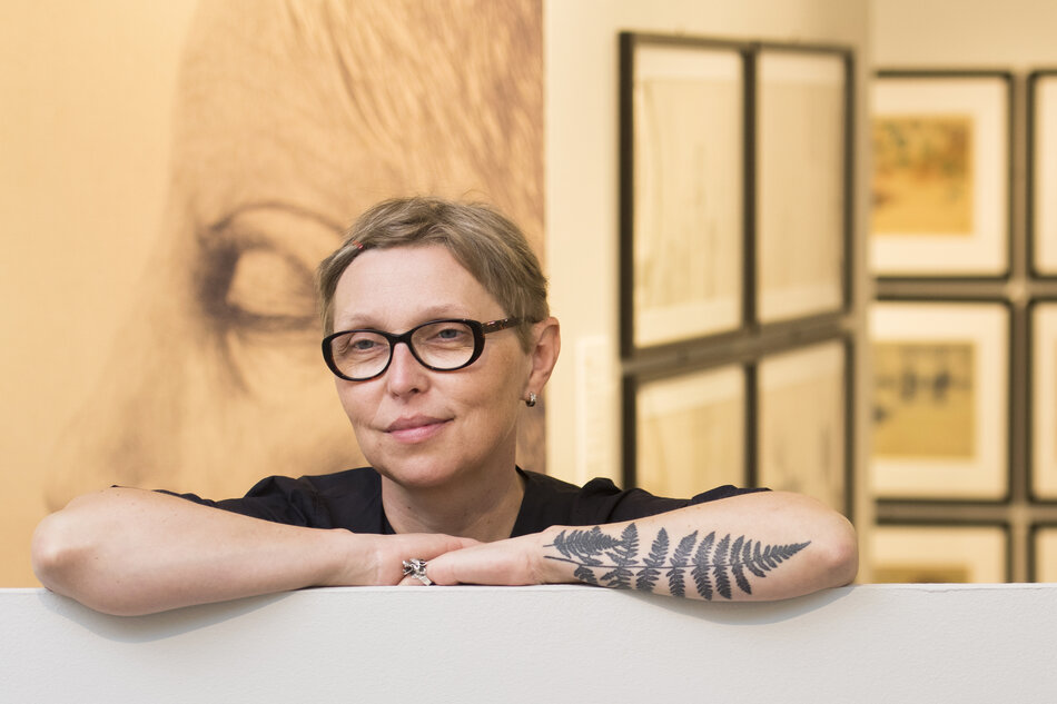 kobieta w okularach z tatuażem na przedramieniu