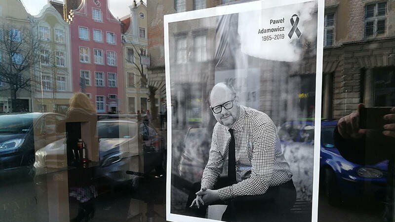 Zdjęcie żałobne Pawła Adamowicza za szybą witryny sklepowej