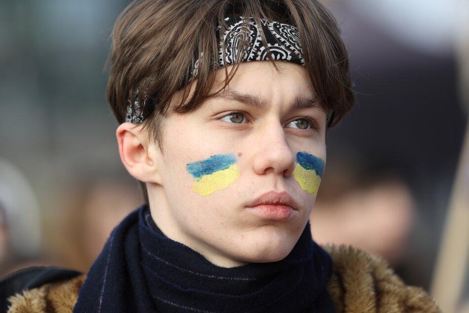 portret nastoletniego chłopaka, na policzkach ma namalowane flagi ukrainy