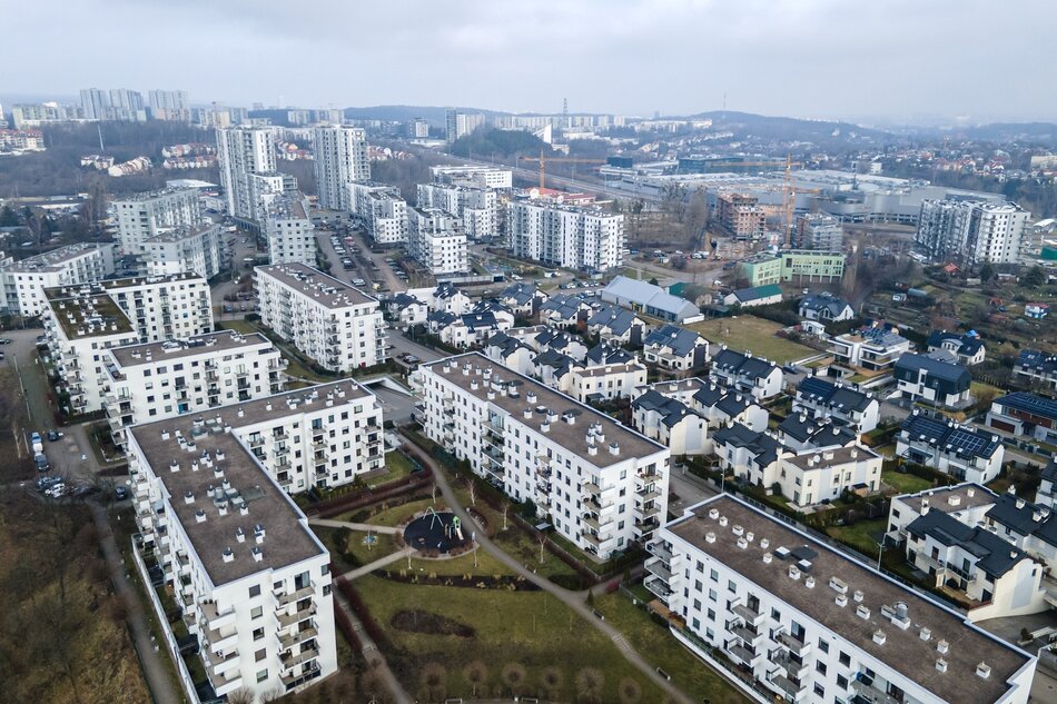 zdjęcie z drona, widać kilkanaście budynków - bloków mieszkalnych, niektóre mają kilka, inne kilkanaście pięter