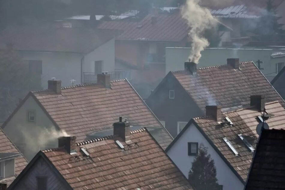Dachy starych domów jednorodzinnych, z kominów wydobywa się dym