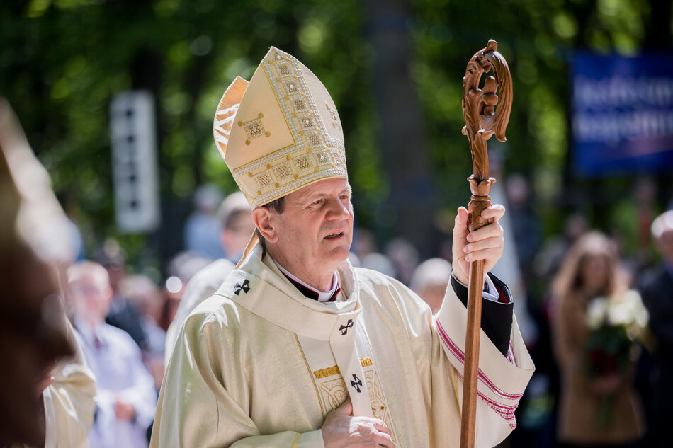 na zdjęciu duchowny, arcybiskup w uroczystym stroju w jasnym kolorze