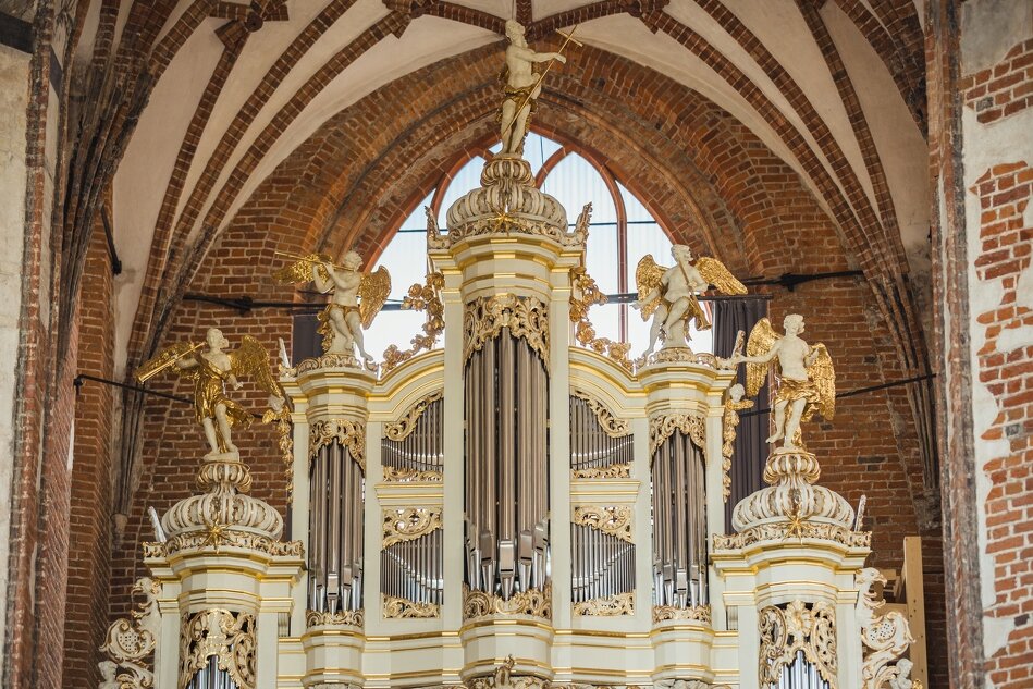 imponujące kremowo-złote organy w kościele z czerwonej cegły
