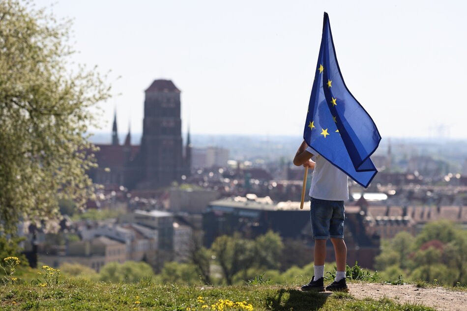 Chłopiec z flagą Unii Europejskiej na tle panoramy Gdańska