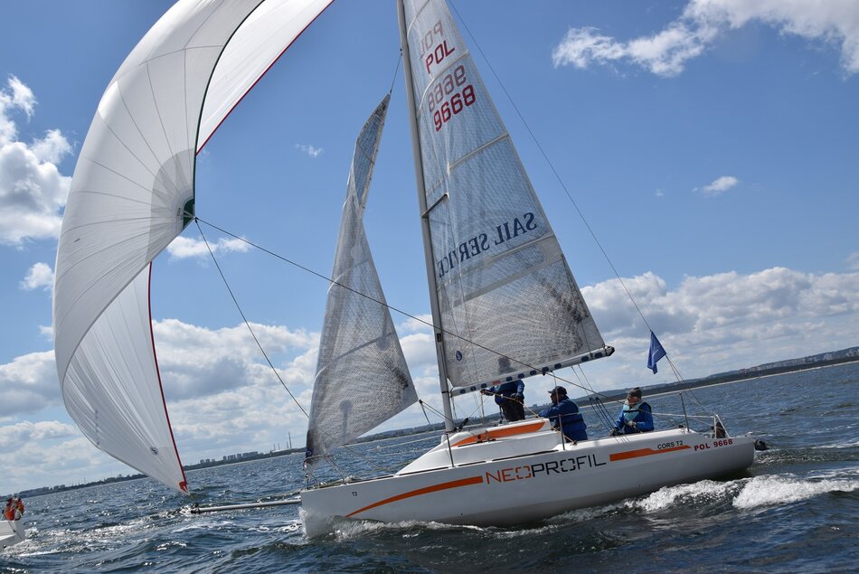 Jacht z postawionymi żaglami na wodzie 