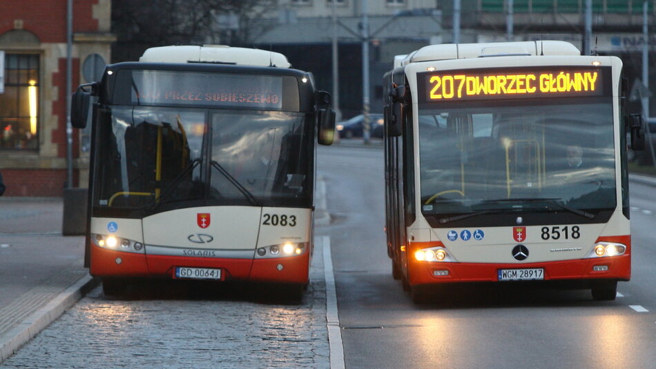 Dwa autobusy obok siebie: po lewej na zatoczce przystankowej, po prawej na jezdni