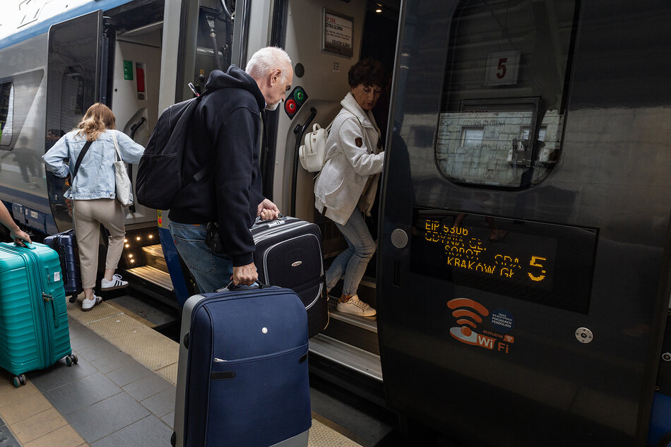 Pasażerowie wsiadają z peronu do pociągu.