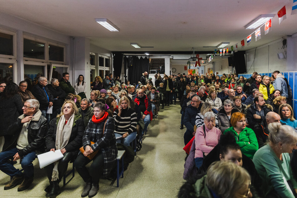 na zdjęciu pomieszczenie wypełnione tłumem osób, większość siedzi na krzesłach