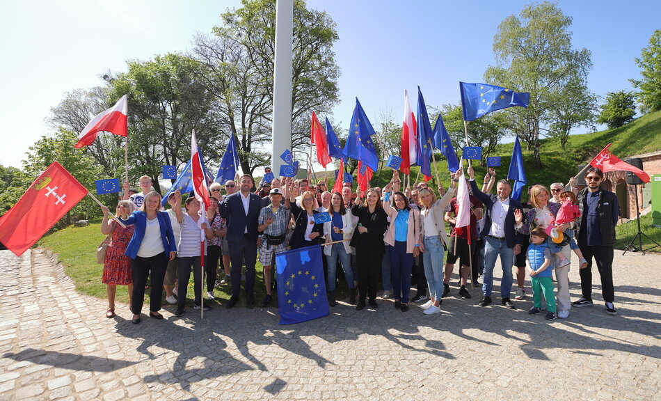 Grupa osób z flagami polskimi, gdańskimi i europejskimi