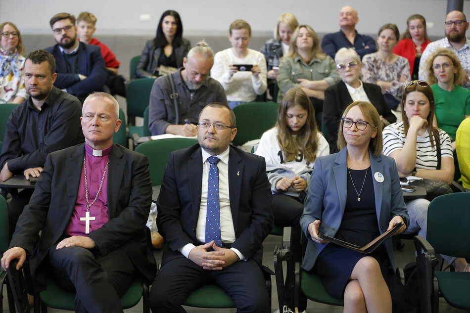 W sali obrad siedzą ludzie.