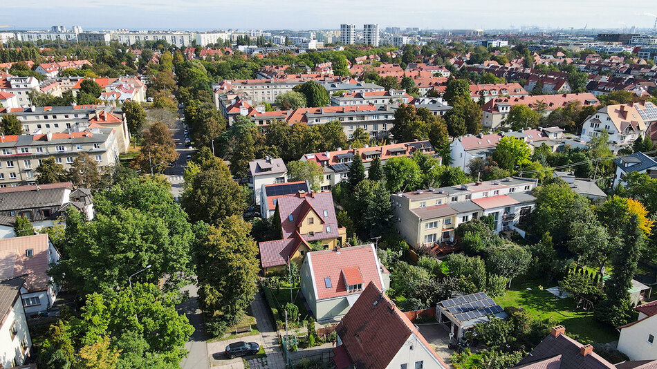 lotnicze zdjęcie dzielnicy mieszkaniowej pełnej niskich domów i zieleni. 