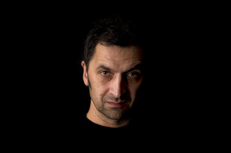 Na zdjęciu twarz mężczyzny na czarnym fotograficznym tle.