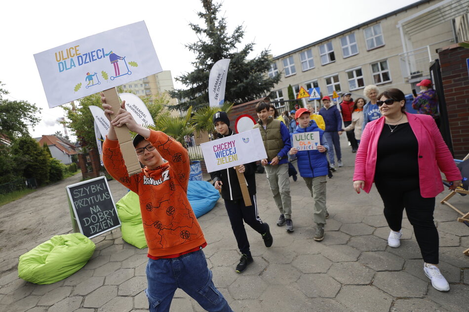 Dzieci ze szkoły maszerują z transparentami w ramach akcji Streets For Kids czyli Ulice dla Dzieci.